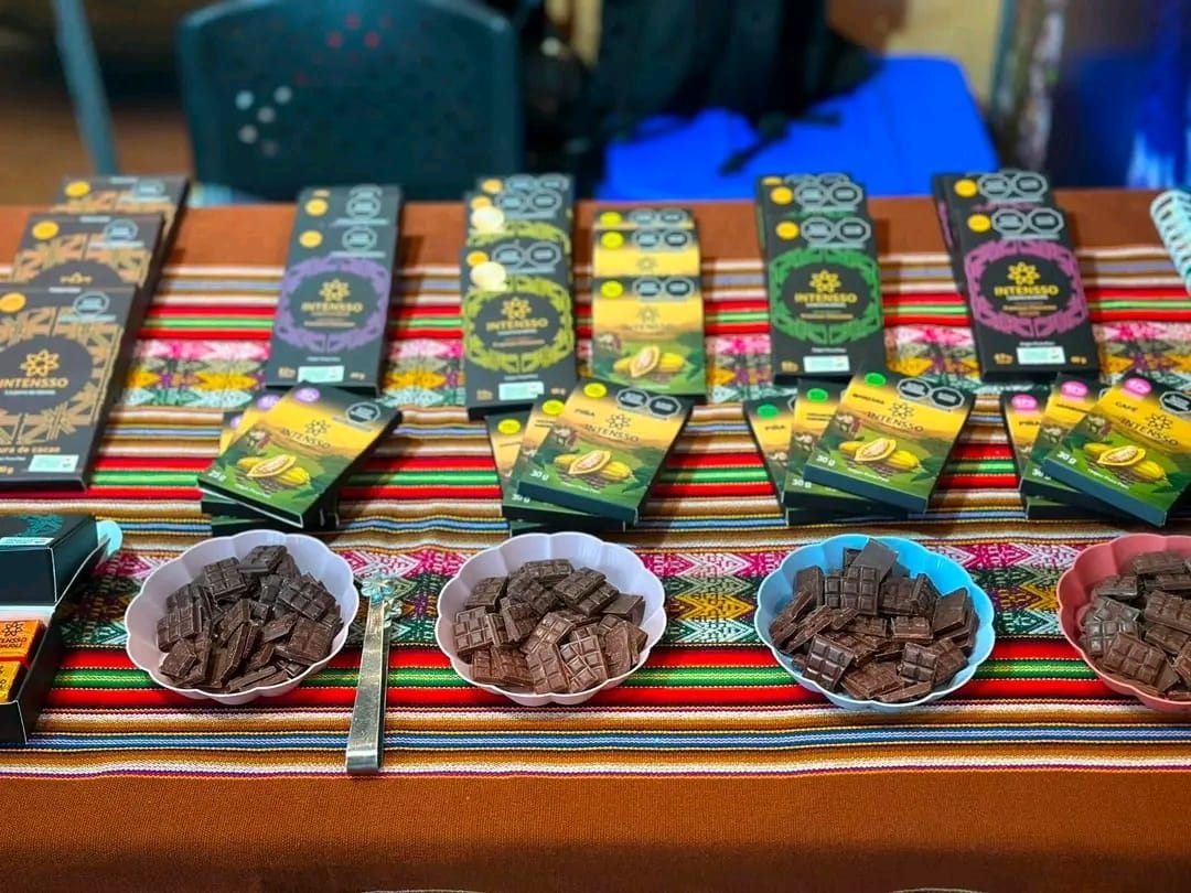 Anaqueles con chocolate en barra y cacao en polvo INTENSSO exhibidos en un stand